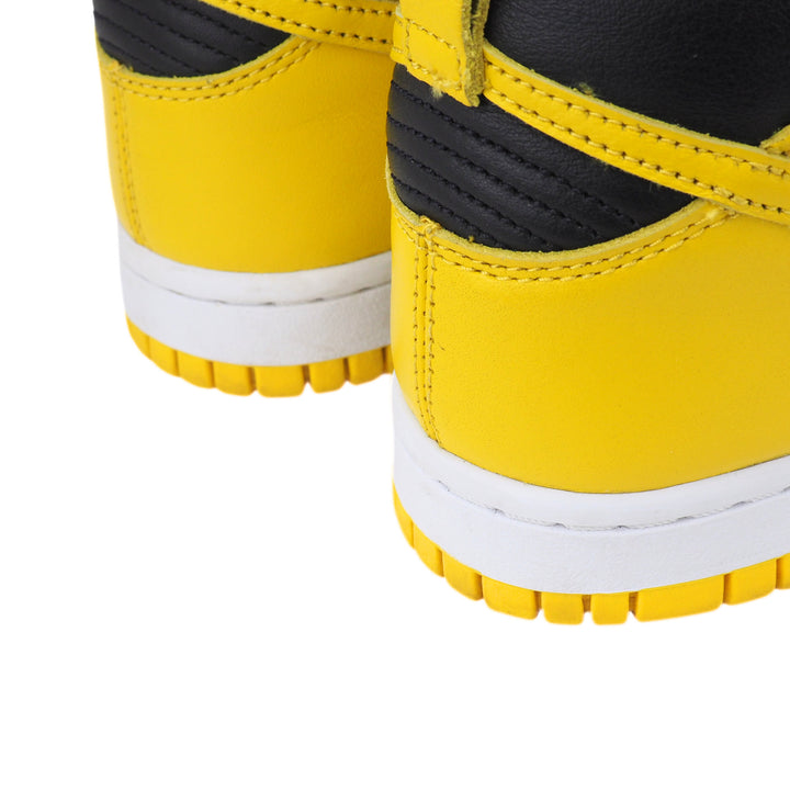 Close-up of yellow sneakers with black accents on a white background