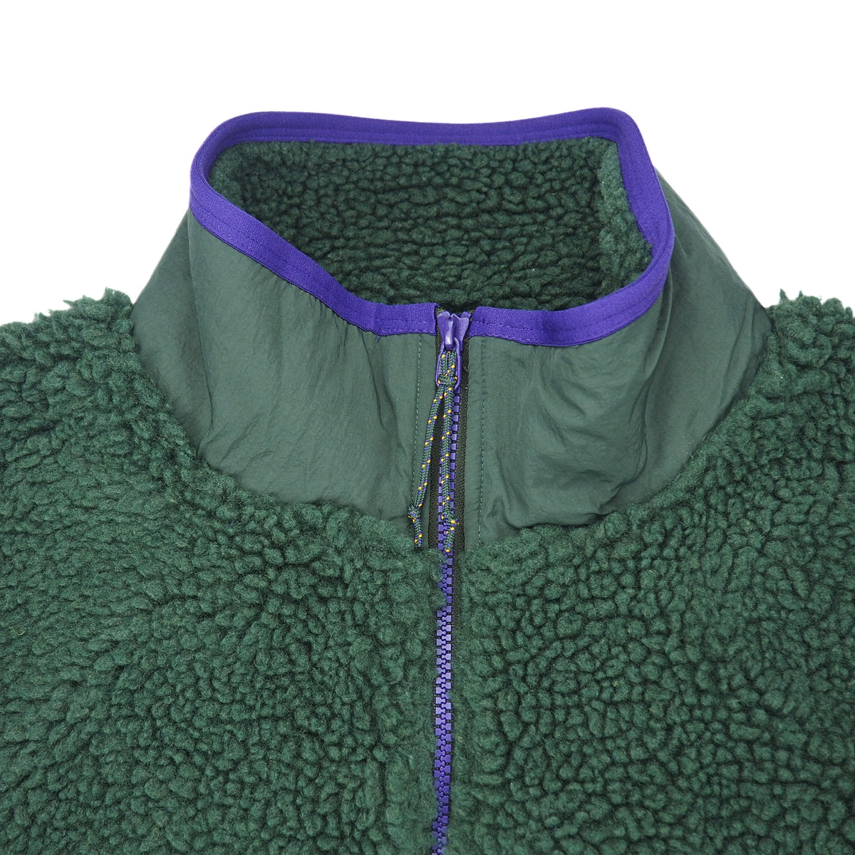 Close up detail of the chest and collar of a green fleece vest with purple zipper and trim on a white background.