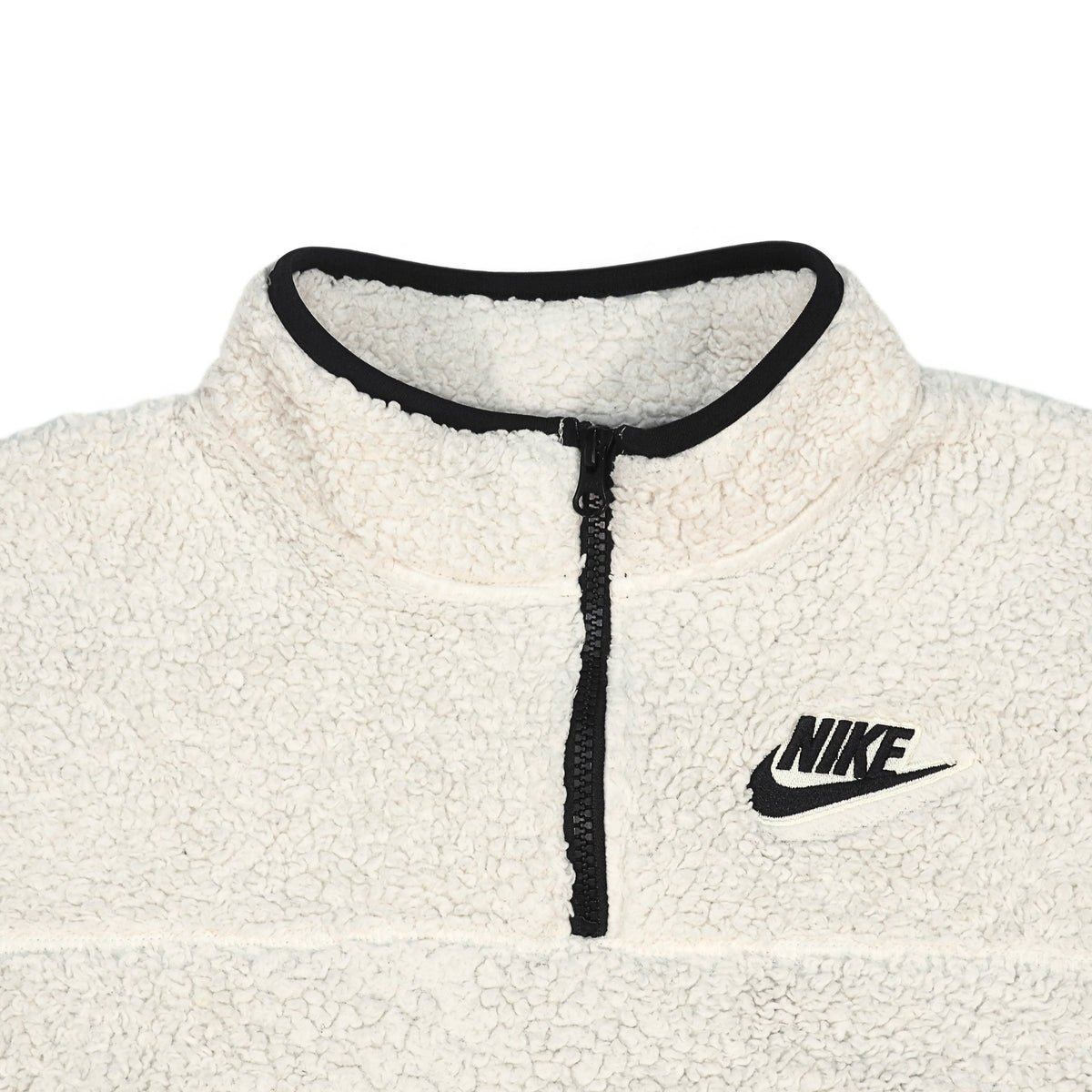 Close-up of a Nike fleece pullover in off-white with a black zipper, black collar trim, and a black Nike logo on the chest.