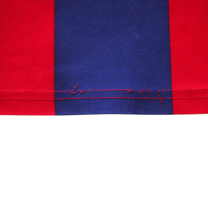 Close-up of red and blue fabric hem with visible loose stitching on a white background