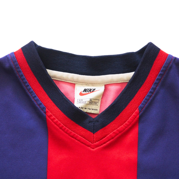 Close-up of the collar of a vintage Nike FC Barcelona soccer jersey with a red and blue design and 'Nike' tag on a white background