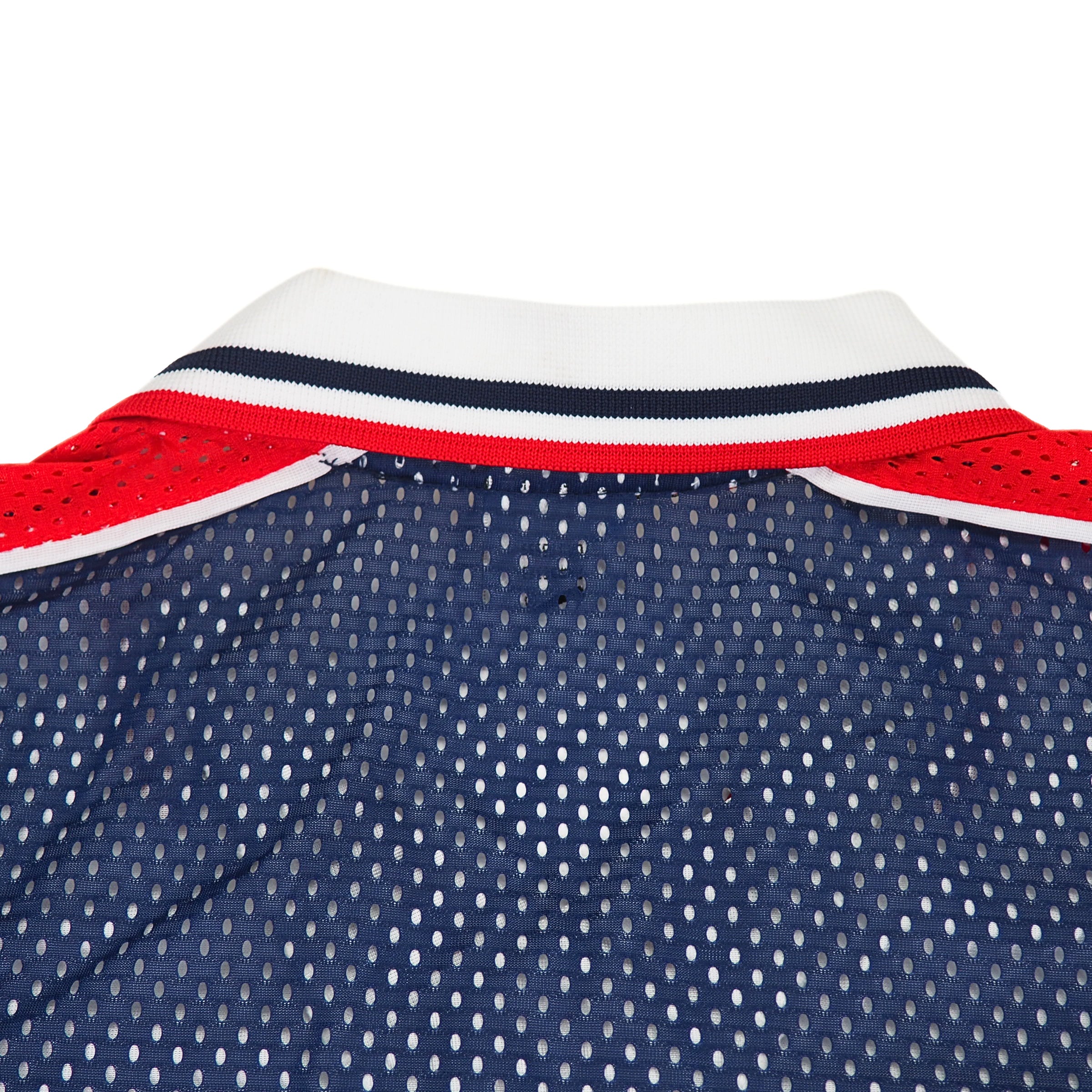Close-up of the back collar of a nike team sports team usa soccer jersey with red, white, and blue mesh fabric and tricolore woven trim on a white background