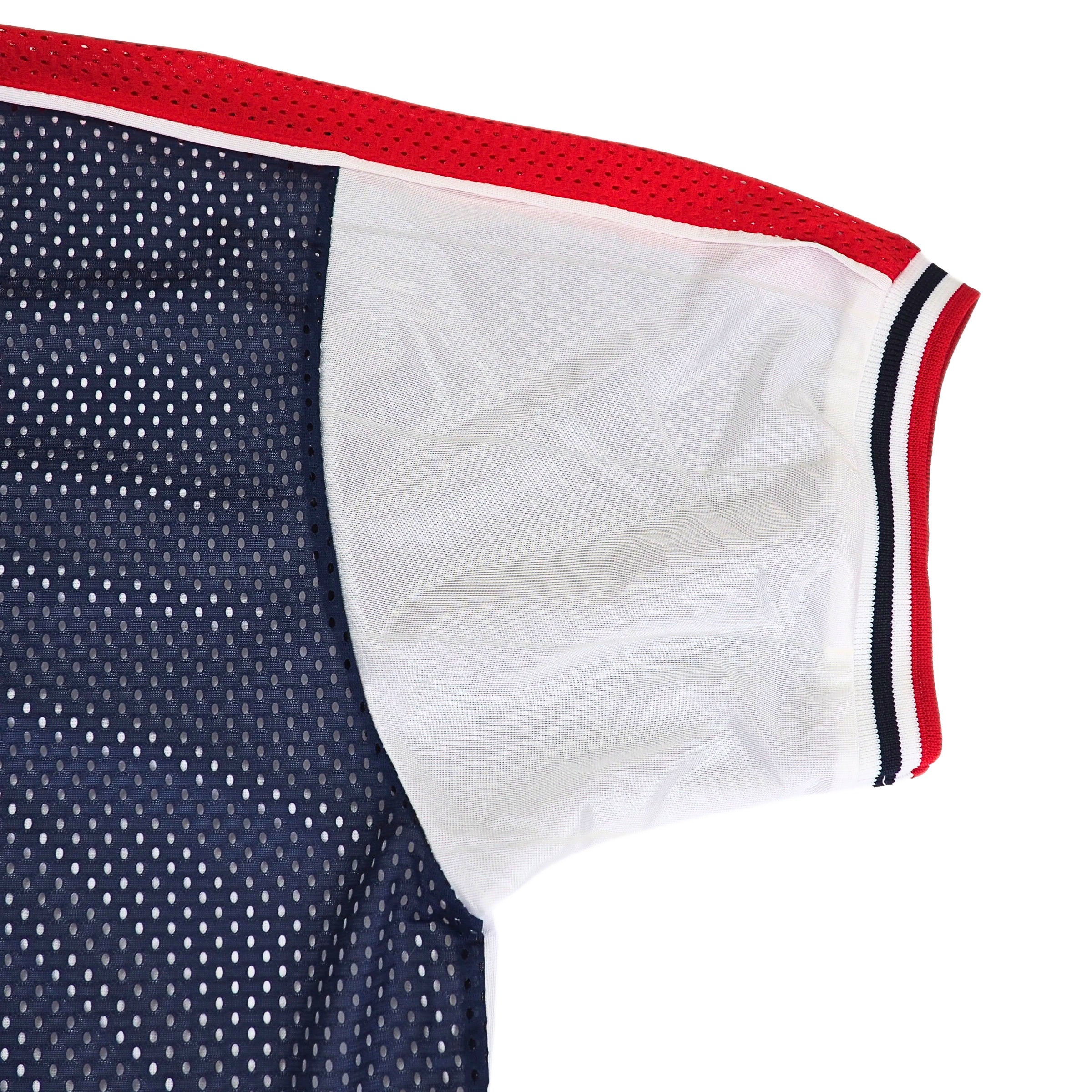 Close-up of a nike team sports team usa jersey with red and blue mesh, white satin, and a tricolore elasticated trim on a white background