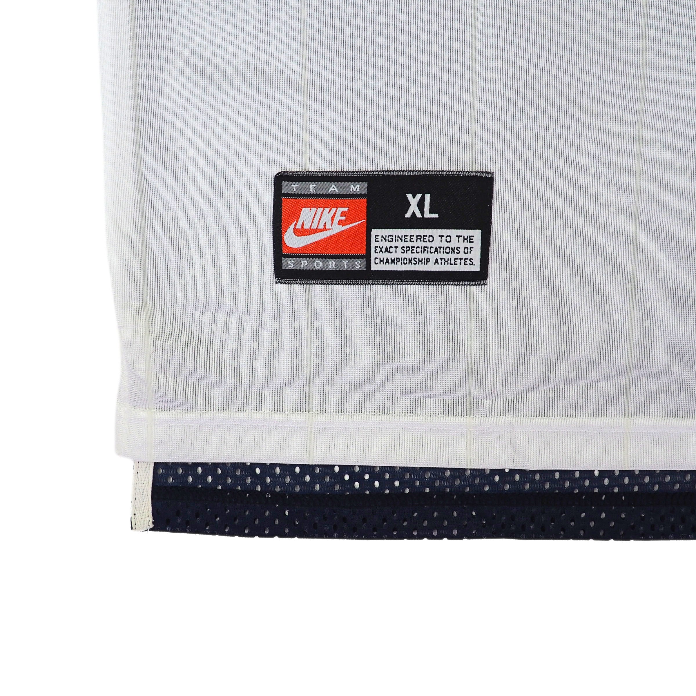 Close-up of a Nike Team Sports 'jock tag' logo on a white jersey on a white background