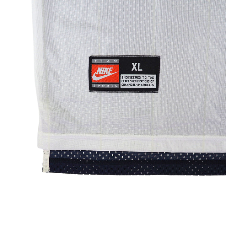 Close-up of a Nike Team Sports 'jock tag' logo on a white jersey on a white background