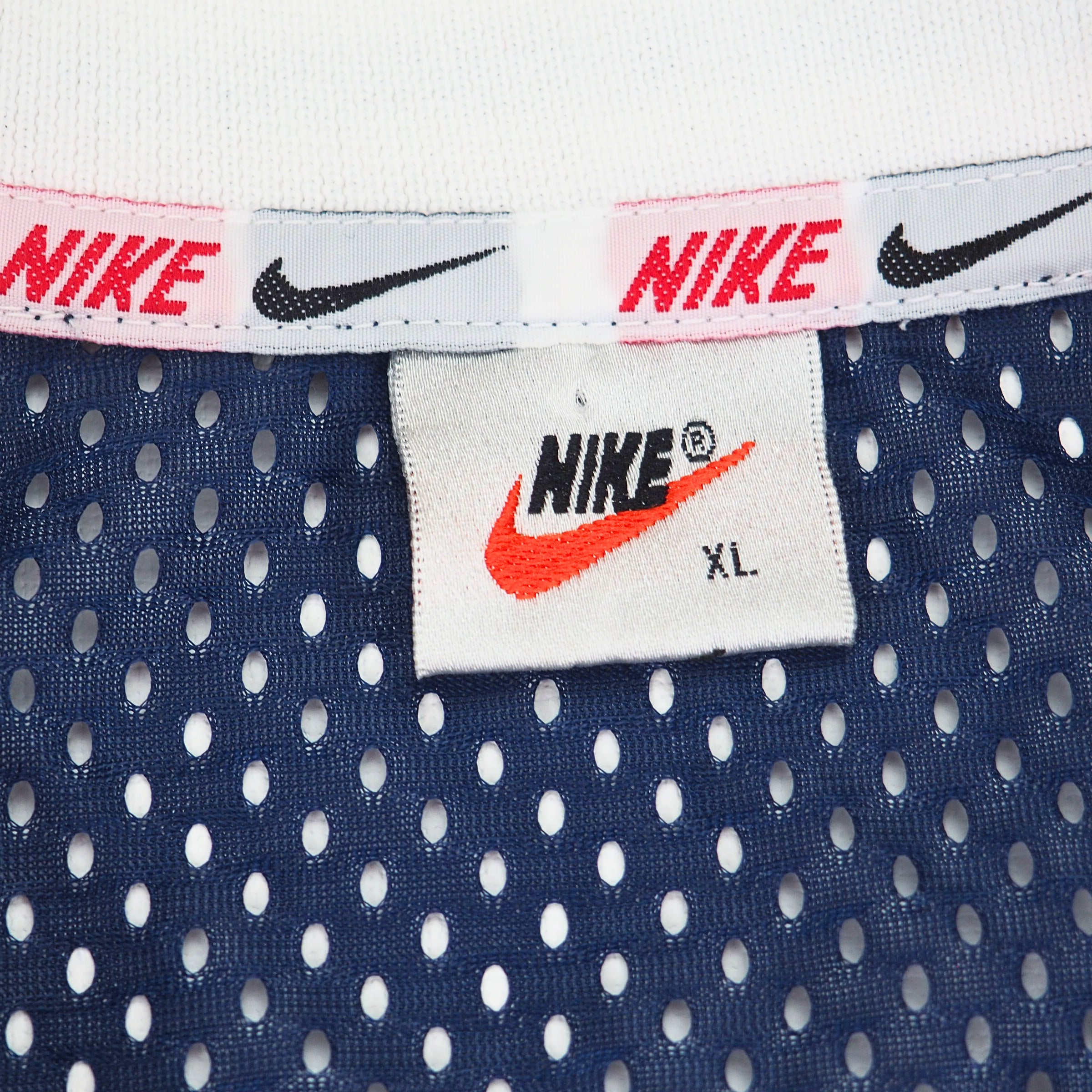 Close up of vintage 90s Nike tag with XL sizing and Nike Swoosh branded ribbon on inside collar of Team USA soccer jersey