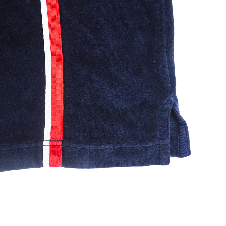 Close up of the hem of a blue velour jacket with red and white stripe