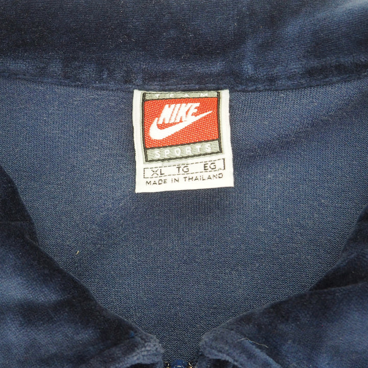Close up of a vintage Nike Team Sports brand tag on the inside collar of a navy blue velour jacket