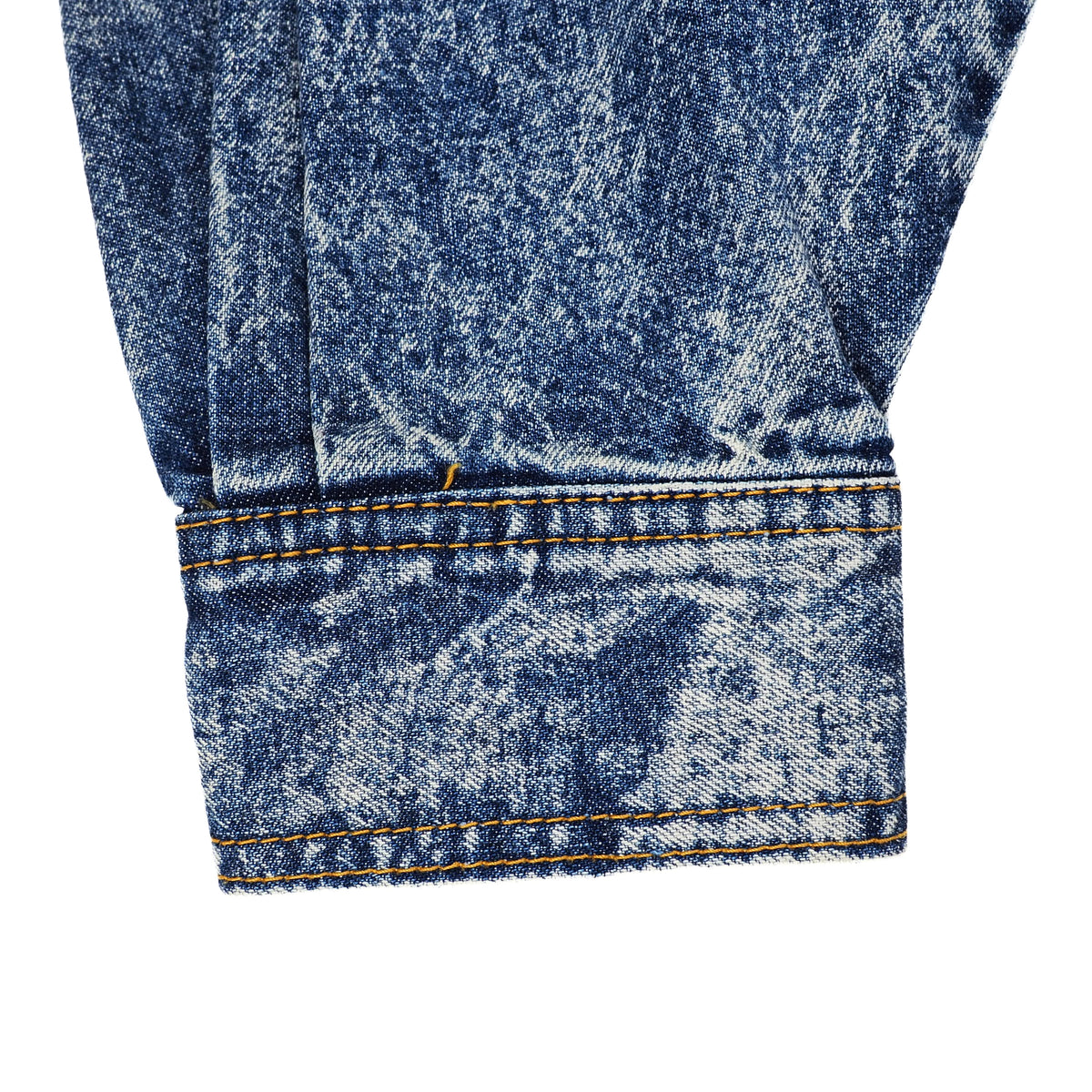 Close-up detail of a denim garment cuff showing the blue washed fabric texture and orange contrast stitching on a white background.
