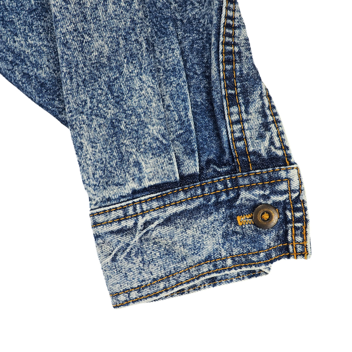 Close-up detail of a blue denim jacket sleeve showing the brass buttoned cuff with orange contrast stitching.