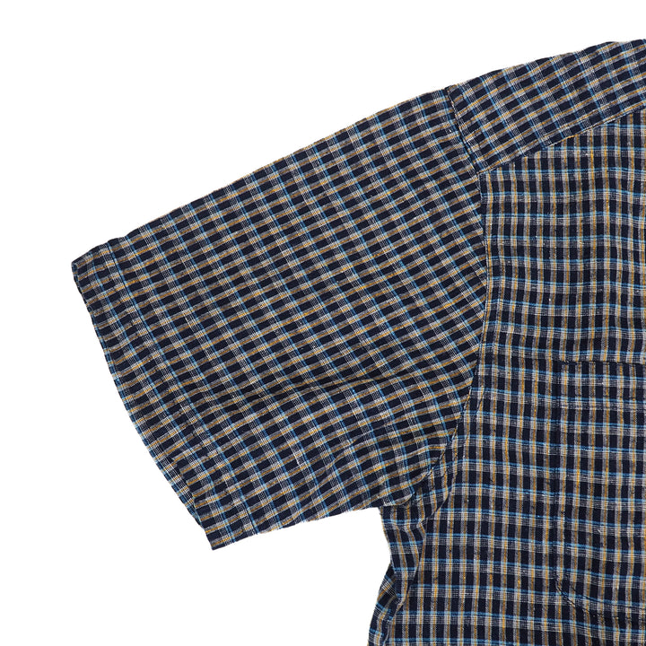 Close-up of a plaid fabric shirt sleeve with blue and brown pattern on a white background