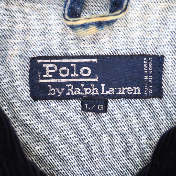 Close-up of a Polo by Ralph Lauren denim label on a light blue and white twill fabric garment.