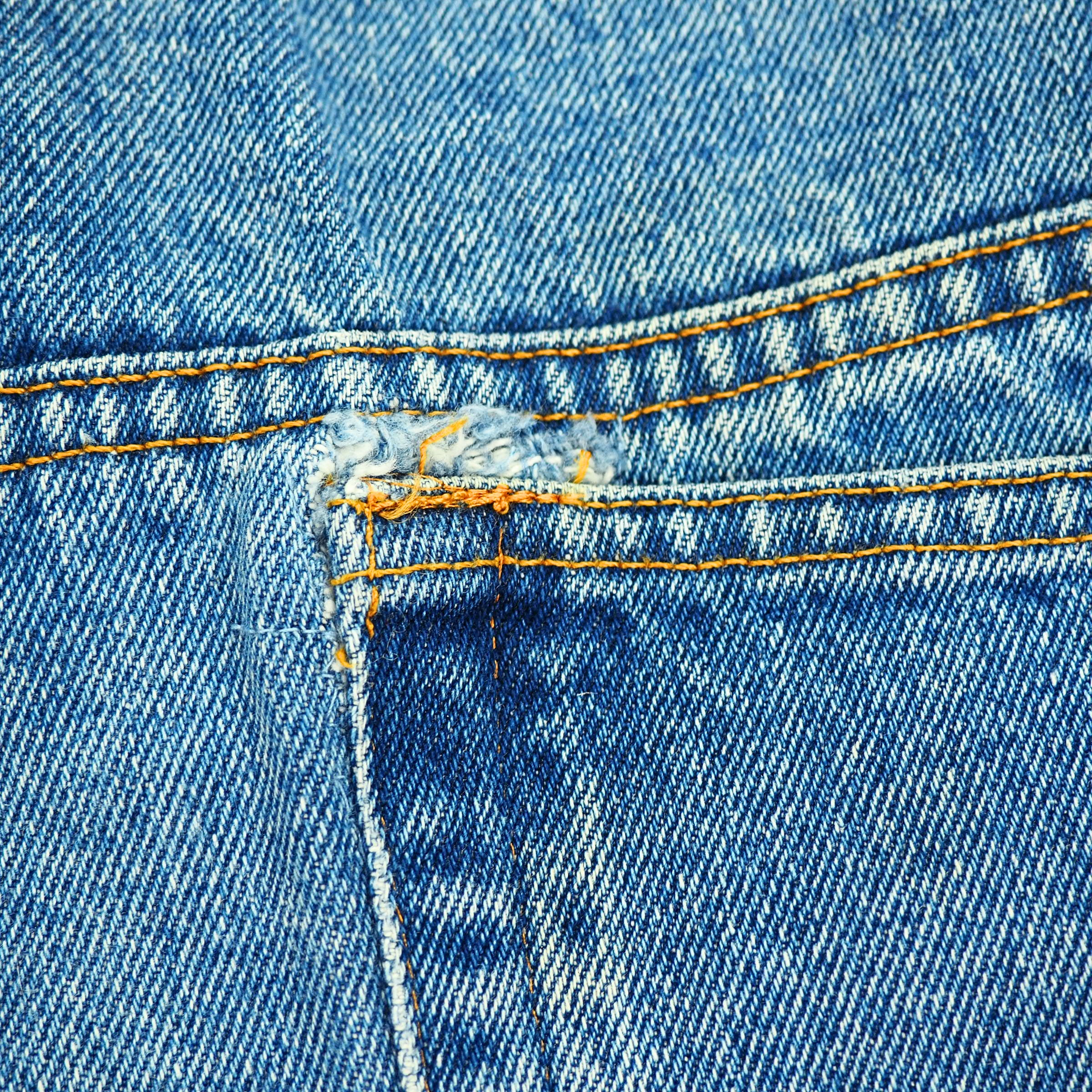 Close-up of blue denim jean pocket with stitching details
