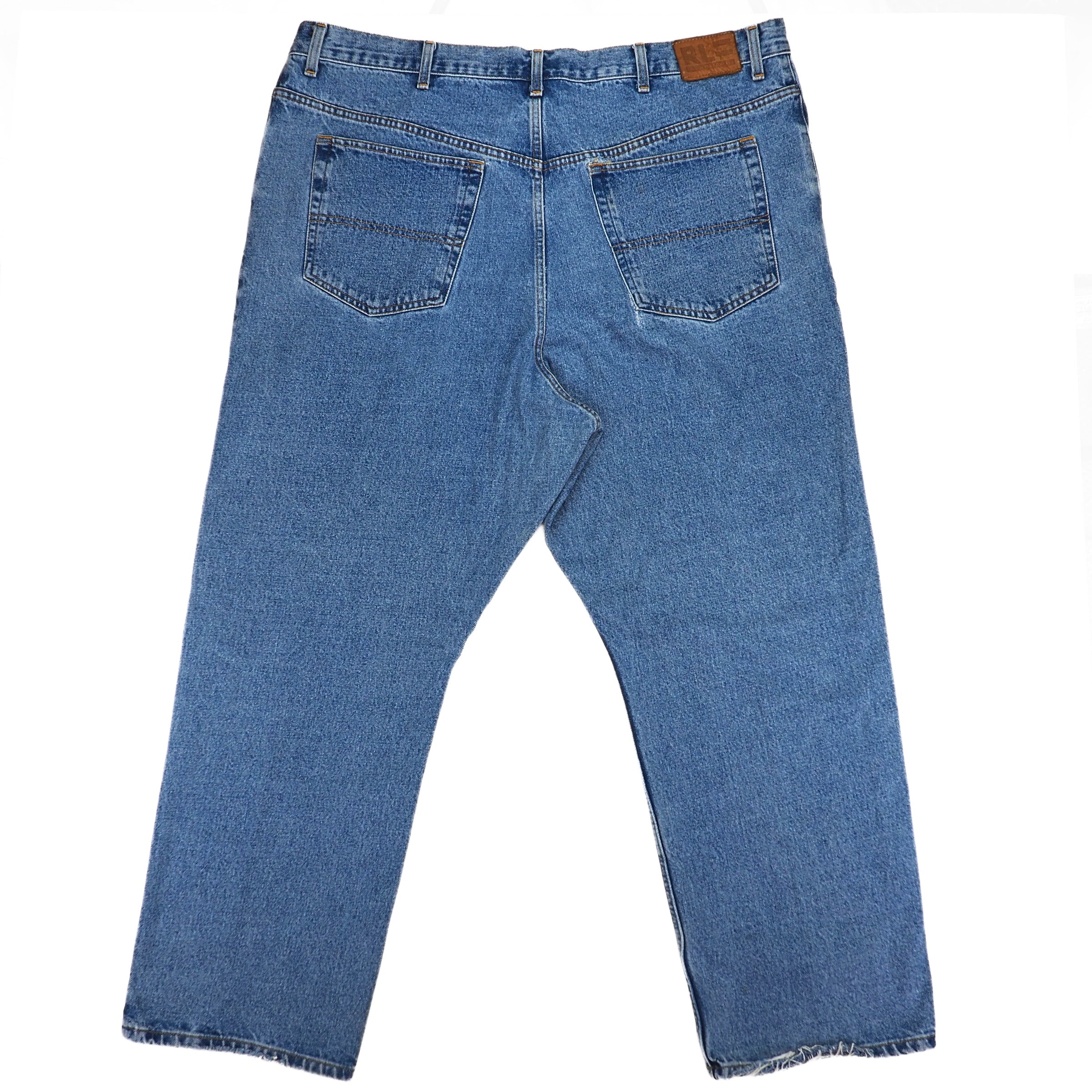Rear view of a pair of blue denim jeans with a brown leather Ralph Lauren jarcon patch on a white background