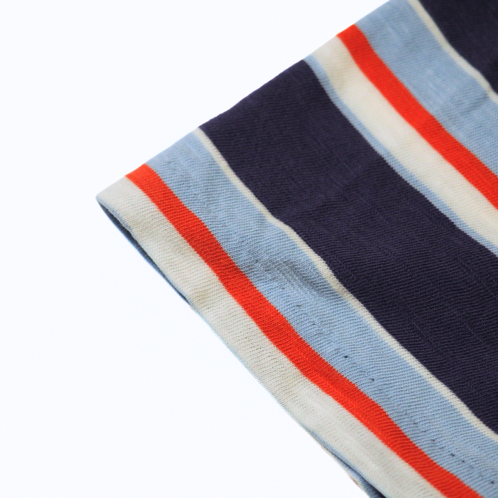 Close-up of a striped fabric with blue, red, and beige colors on a white background