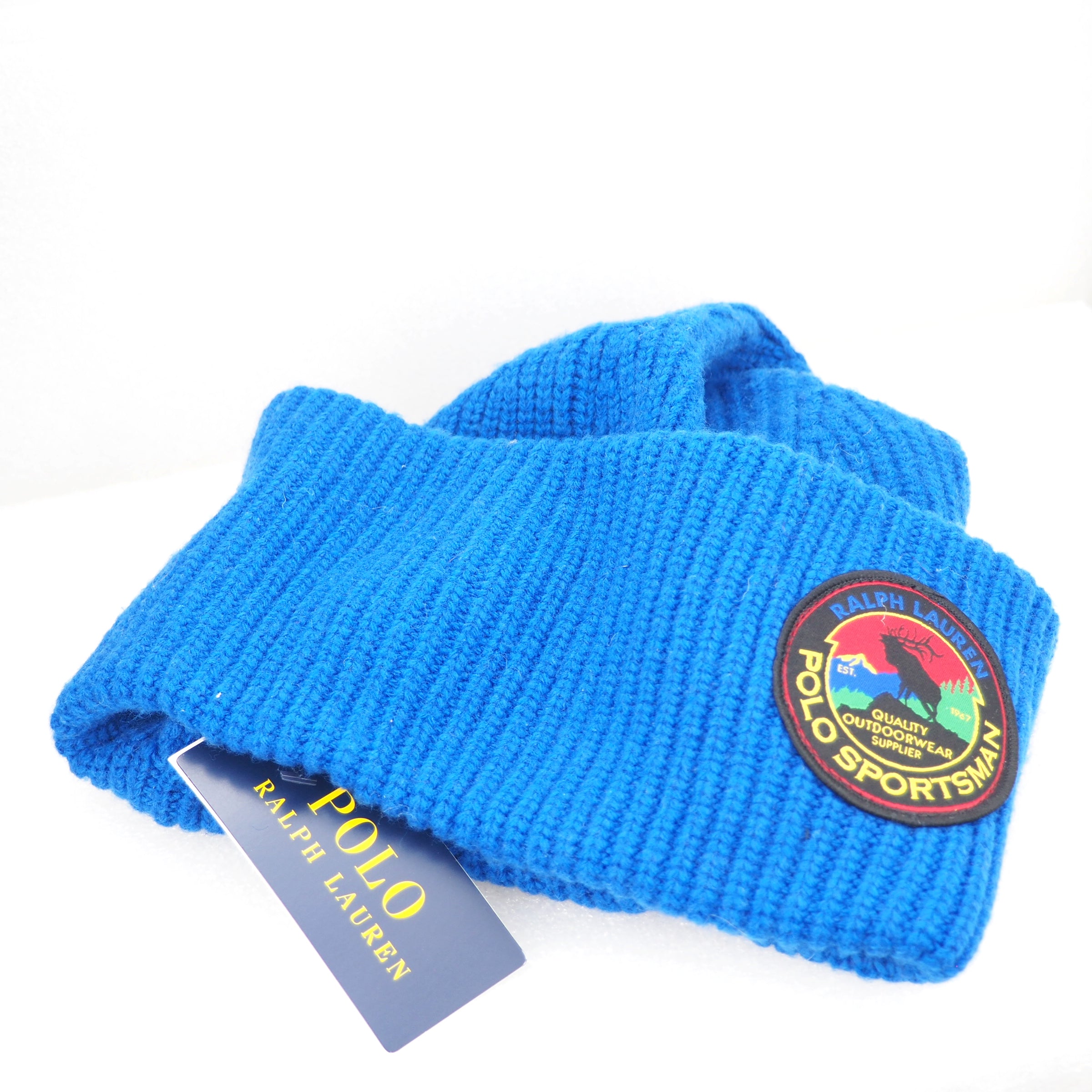 Blue knit beanie with Polo Sportsman logo and Ralph Lauren tag on a white background