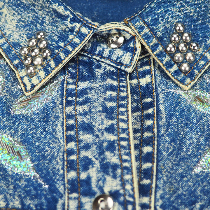 Close-up of a 90s western style acid wash blue denim jshirt collar with decorative buttons, embroidery and stitching.