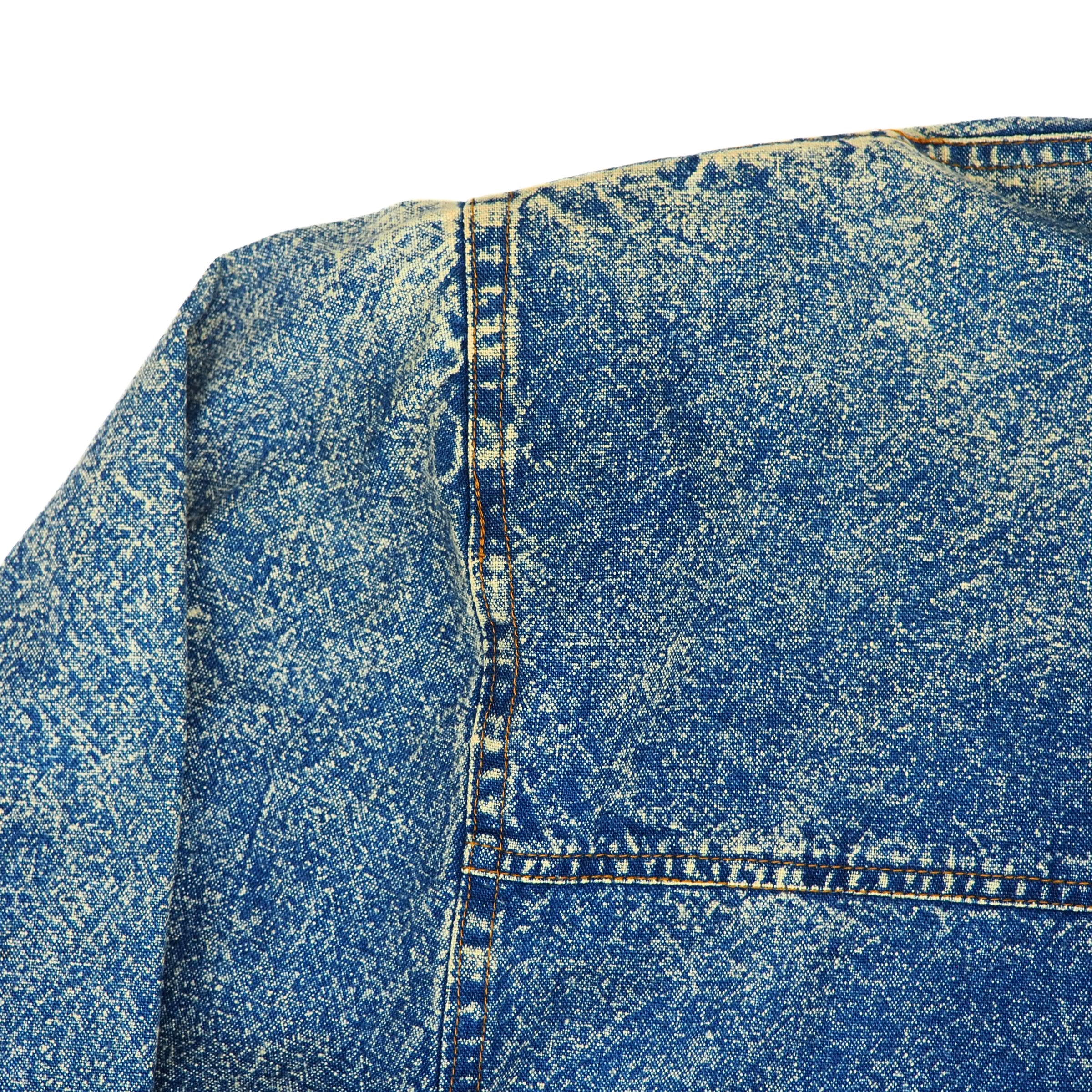Close-up of blue acid wash denim fabric with a worn texture