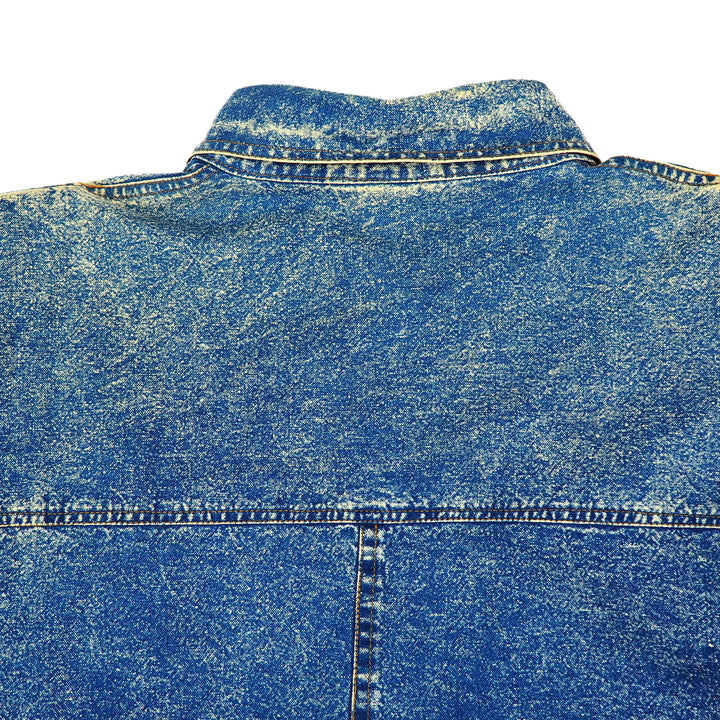 Close-up of a vintage blue acid wash denim shirt neck and collar with a white background