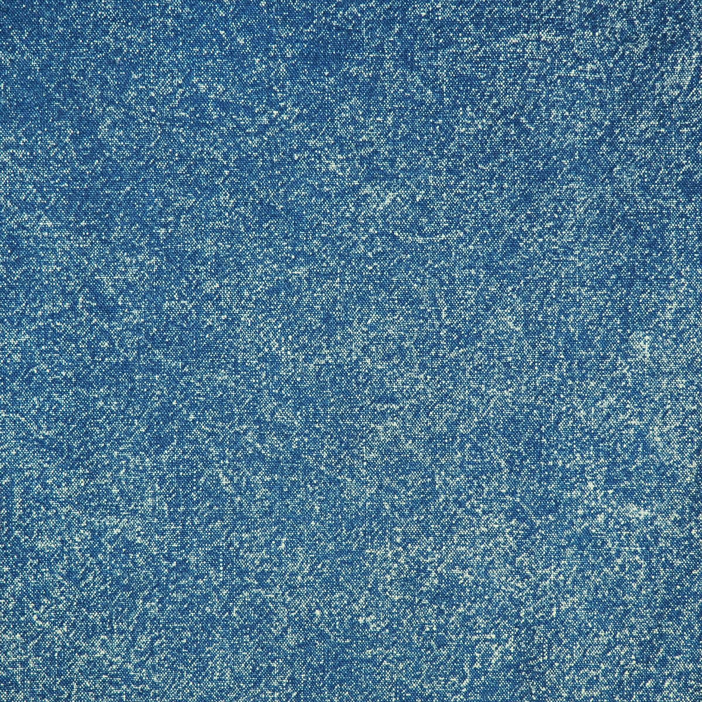 Close-up detail focusing on the texture of a vintage washed blue denim fabric.
