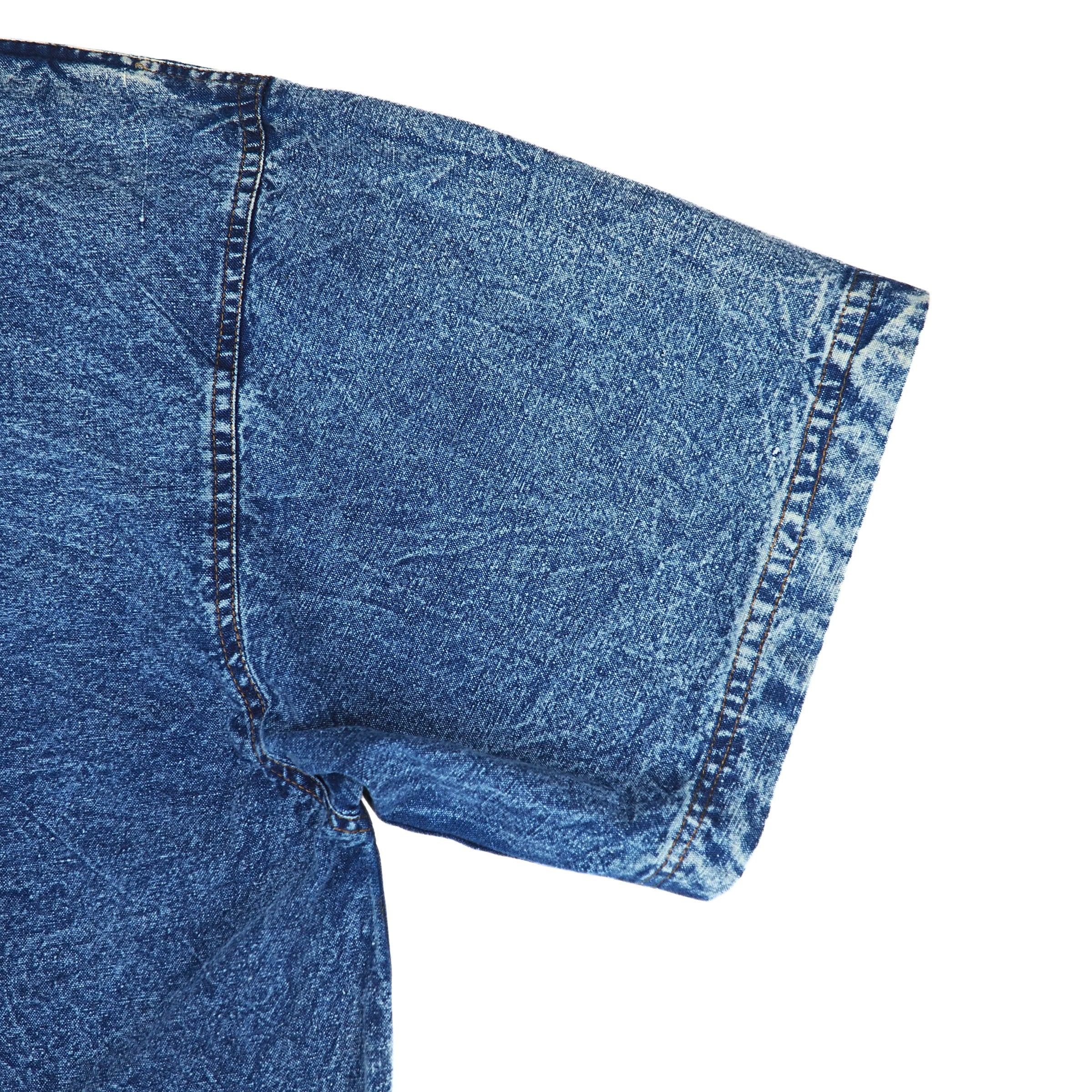 Close-up of blue acid wash denim shirt sleeve on a white background