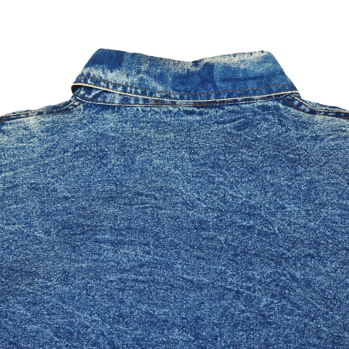 Close-up of a worn blue denim shirt collar on a white background