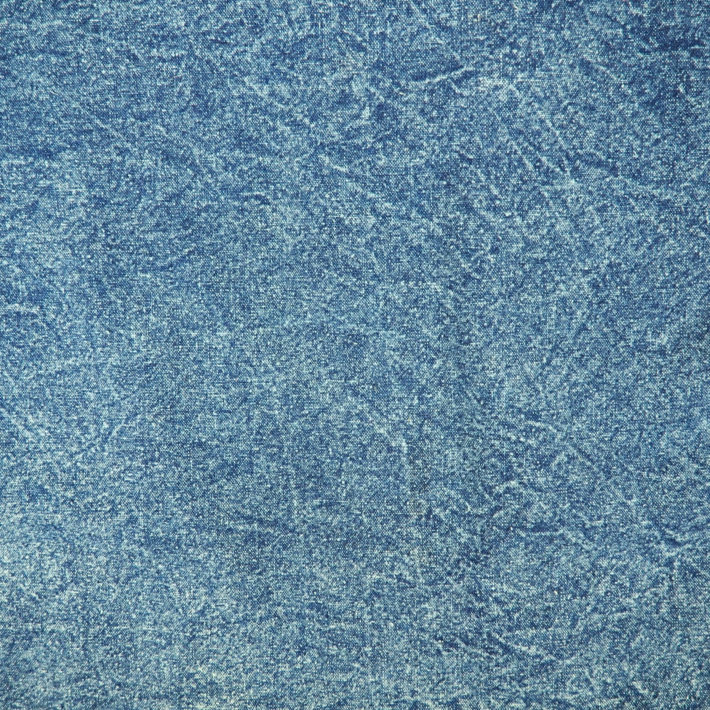 Close-up of textured acid washd blue denim.