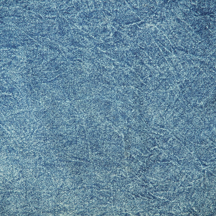 Close-up of textured acid washd blue denim.
