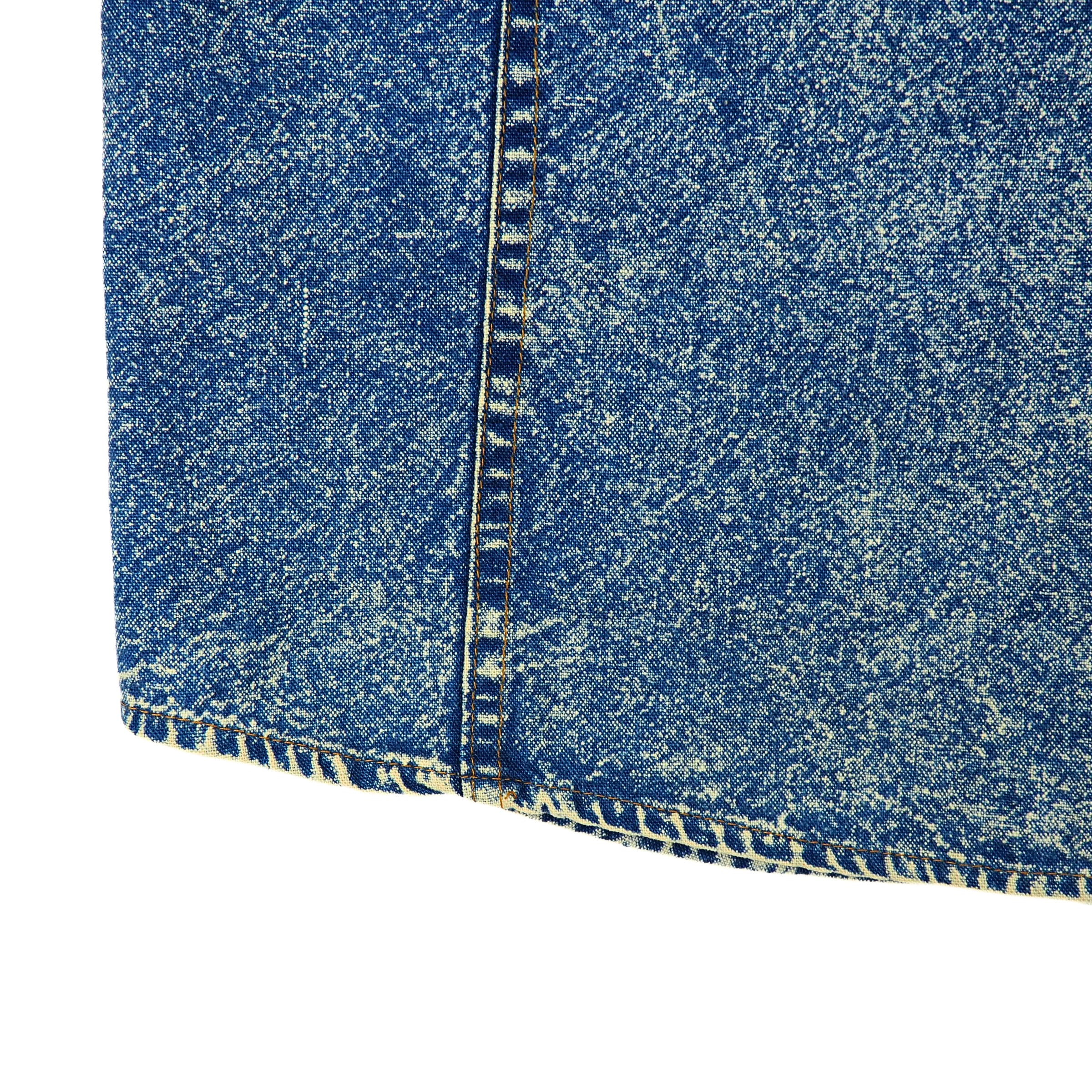 Close-up of blue acid wash denim fabric with a white background