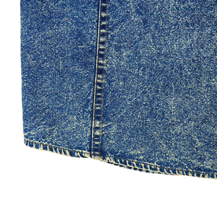 Close-up of blue acid wash denim fabric with a white background