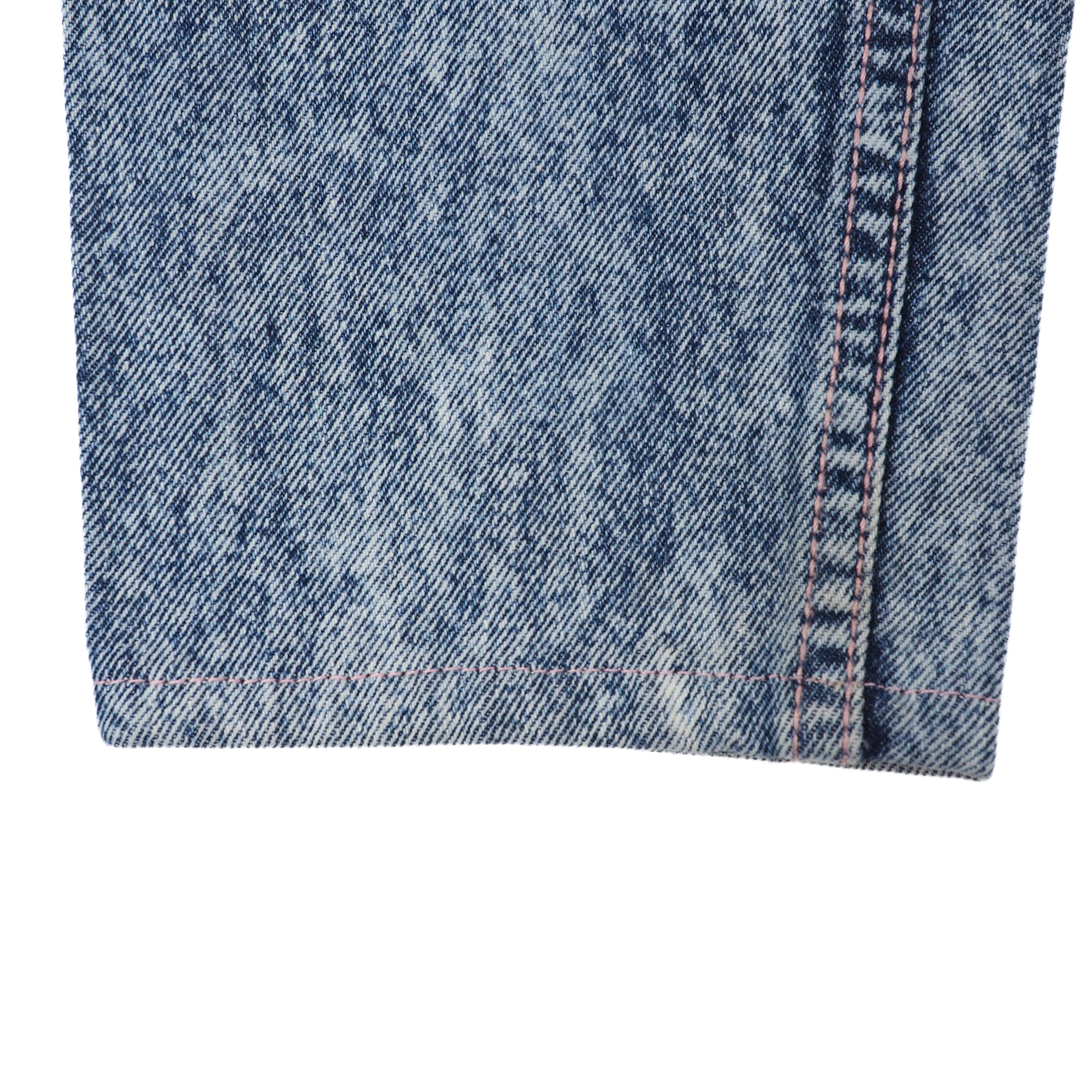 Close-up of blue denim jean pant leg ankle cuff on a white background