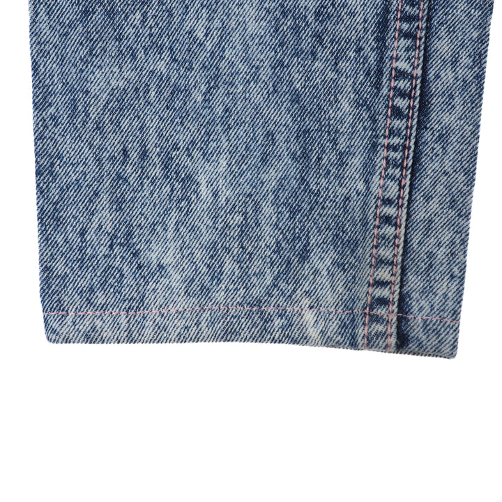 Close-up of blue denim jean pant leg ankle cuff on a white background