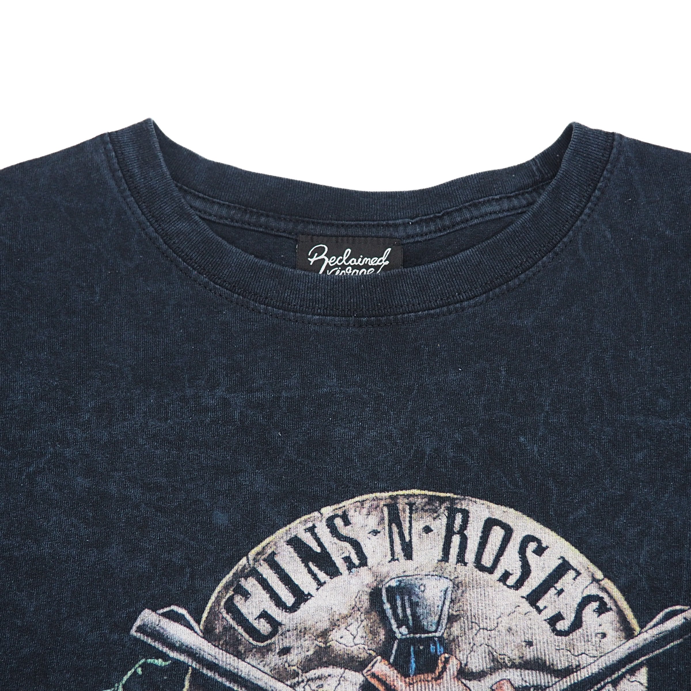 Close up of the chest and collar of a black t-shirt with a 'Guns N Roses' graphic logo on a white background