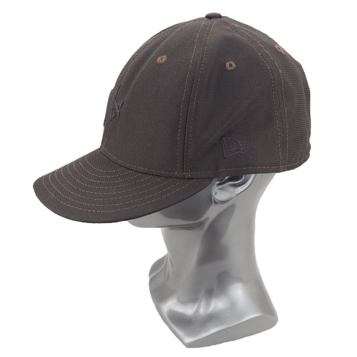 Brown baseball cap on a mannequin head against a white background
