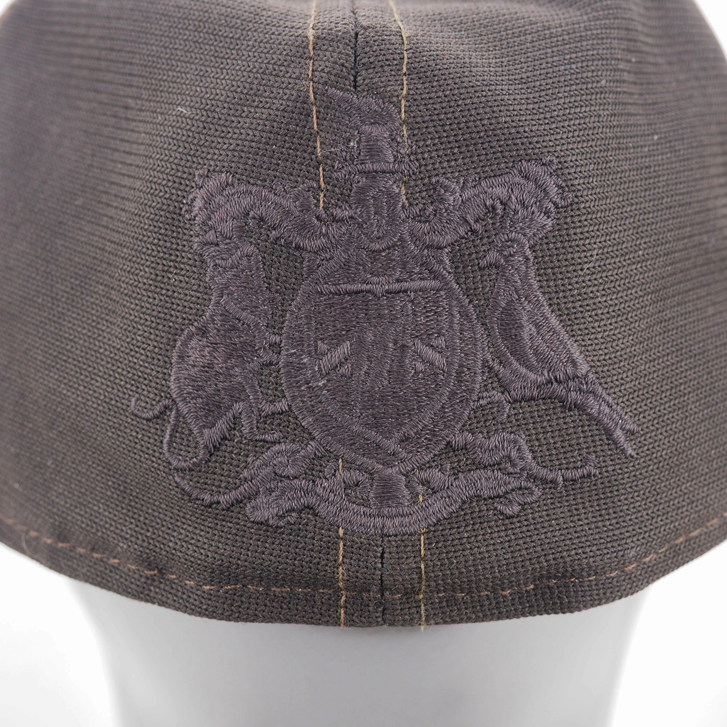 Close-up of a dark gray cap with an embroidered emblem on a white background