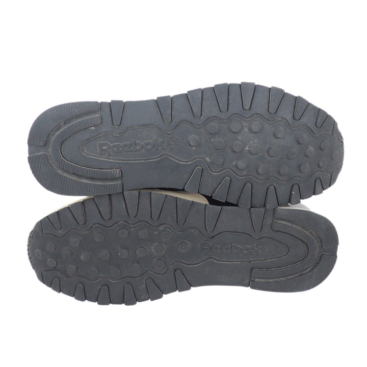 Detail of the soles and tread pattern of a pair of Reebok Classic running shoes on a white background