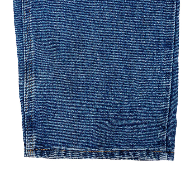 Close-up of blue denim jean pant leg on a white background