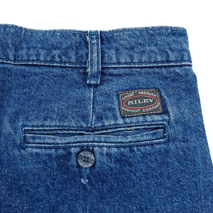 Close-up of blue denim pants with a Riley label on a white background