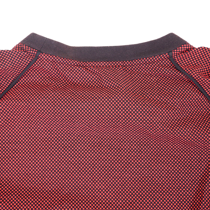 Close-up of the rear collar of a red and black checkered sweater on a white background