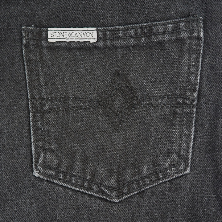 Close-up of a pocket on a dark denim fabric with 'Stone Canyon' label.