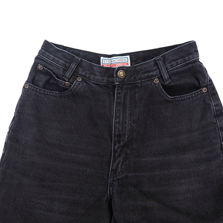 Waist detail of a pair of black jeans with a Stone Canyon brand label on a white background
