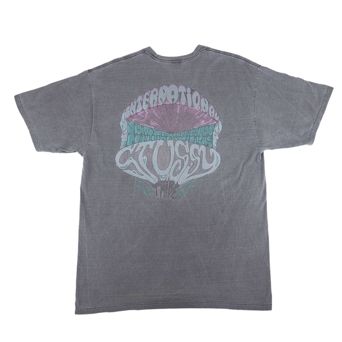Back view of a washed grey graphic t-shirt by Stussy on a white background.