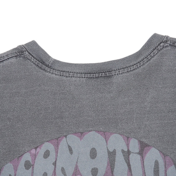 Close-up of the back collar of a washed dark gray t-shirt with a pink and gray graphic design partially visible at the bottom.