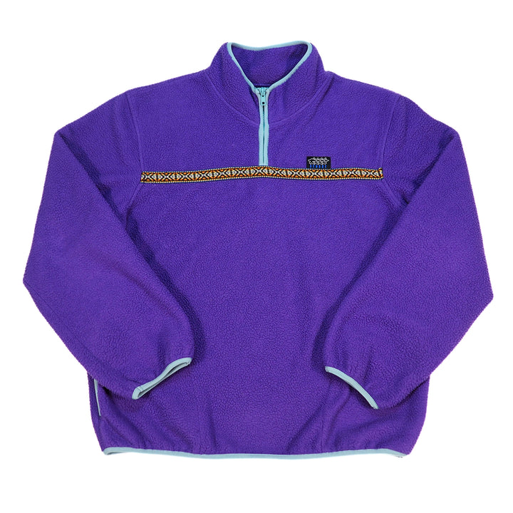 A purple fleece quarter-zip pullover jacket with a light blue zipper, light blue trim, and a decorative horizontal patterned stripe across the chest. A small black Stussy logo is visible on the chest.