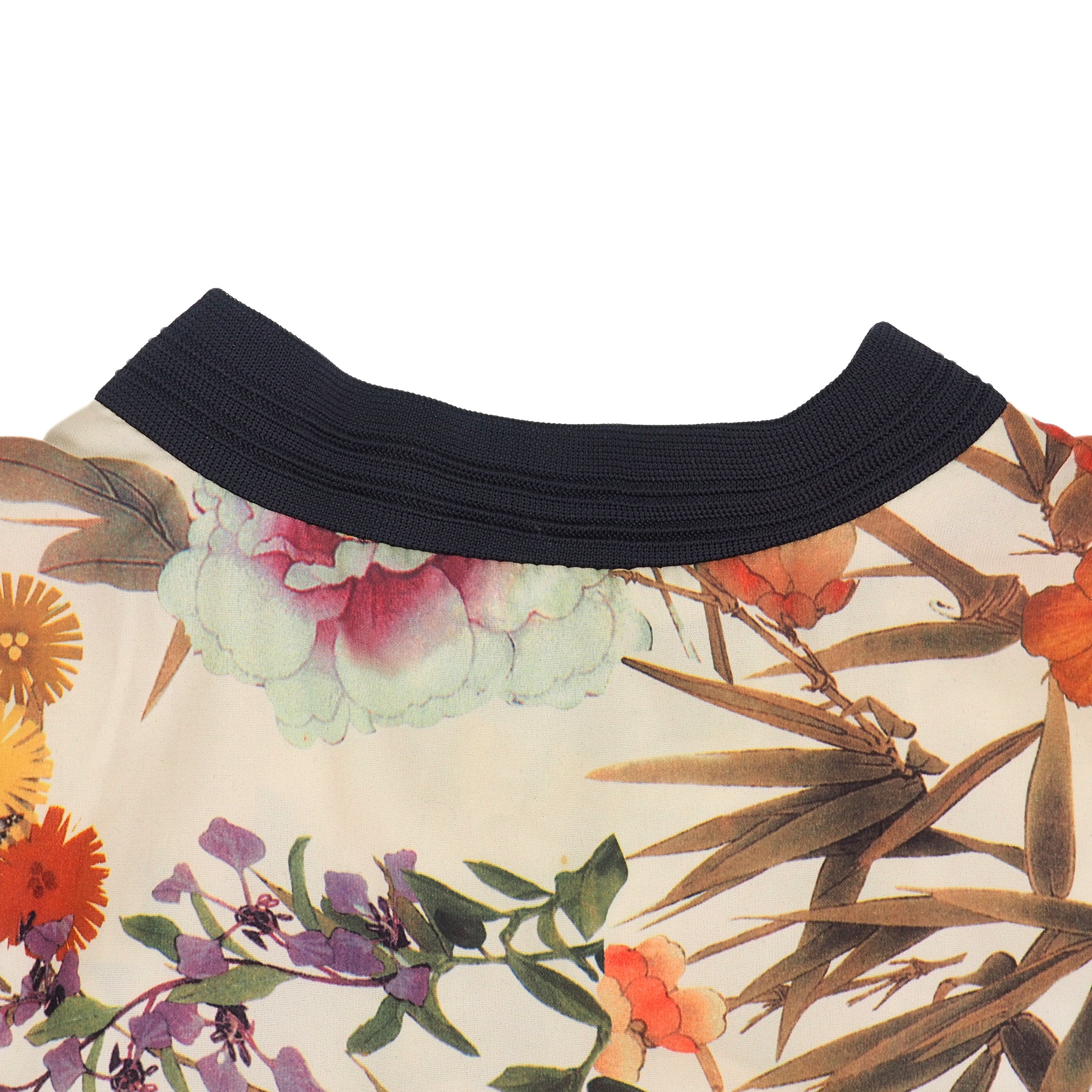 Close-up of a floral-patterned garment with a black neckline on a white background
