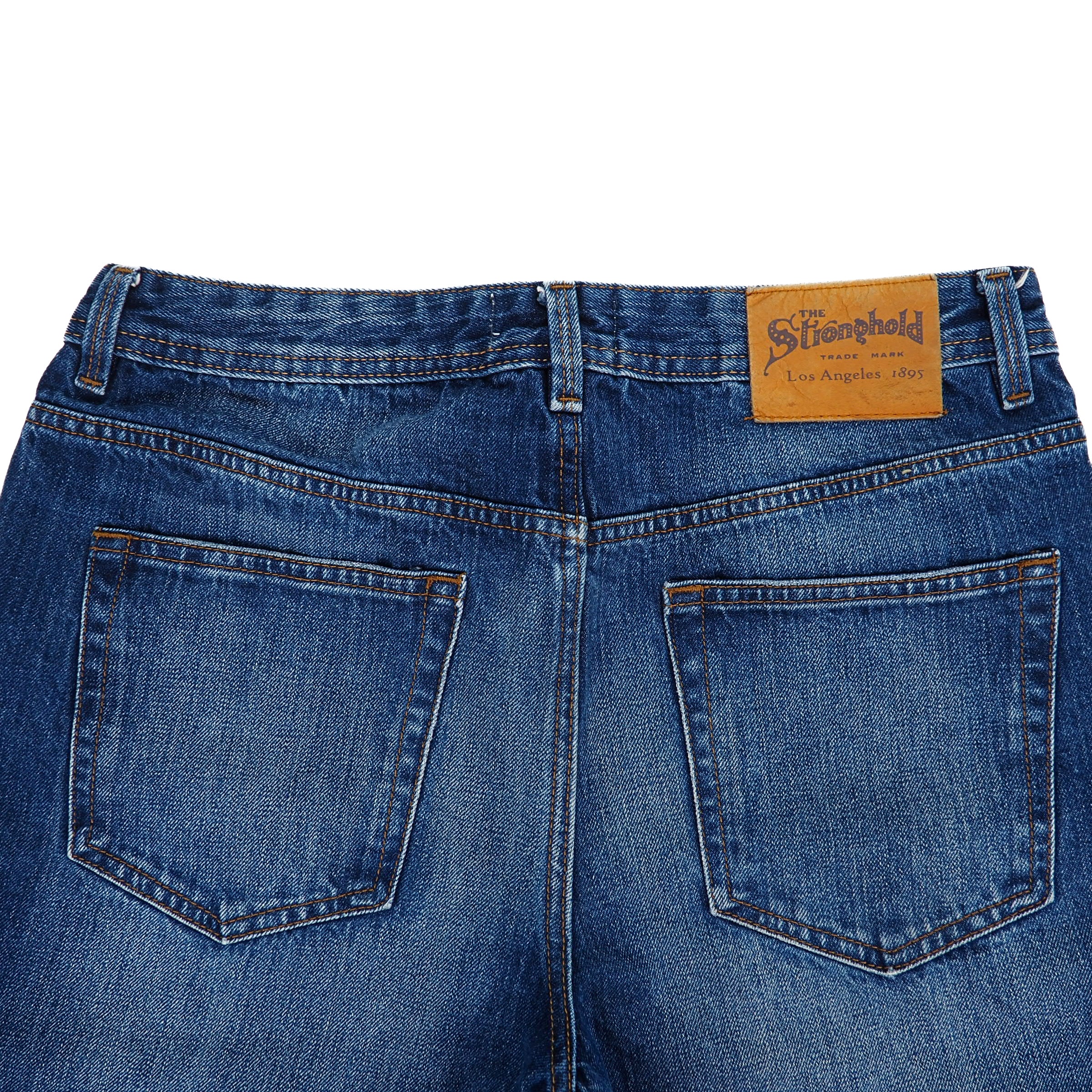 Back view of blue jeans with The Stronghold jarcon patch label on a white background