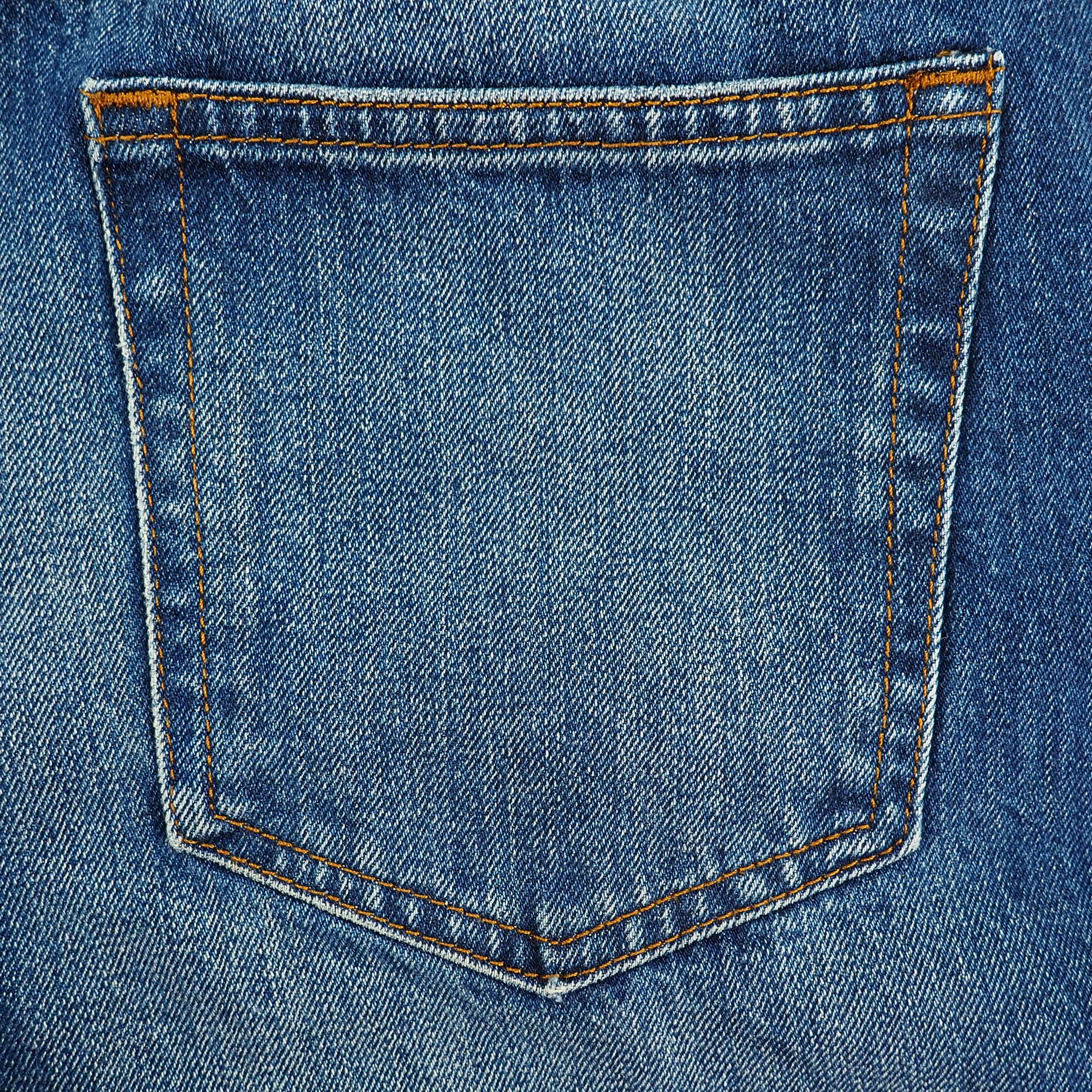 Close-up of a blue denim pocket with orange stitching
