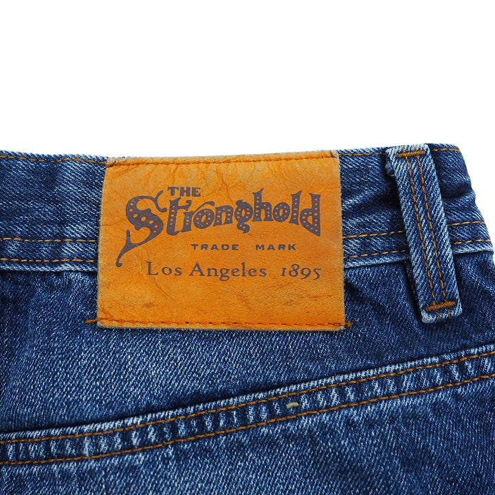 Close-up of a denim label with 'The Stronghold' branding on a white background