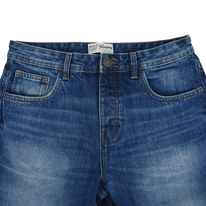 Blue jeans with a The Stronghold brand label on a white background