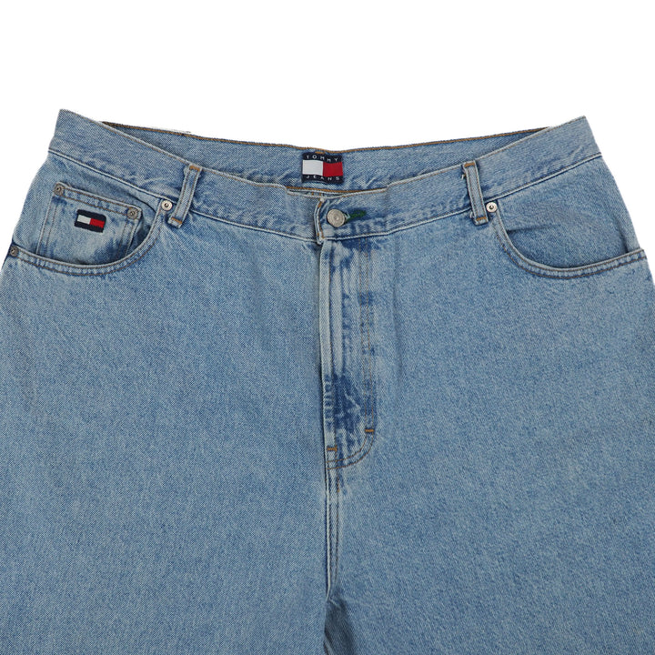 Close-up of blue jeans with a brand logo on a white background